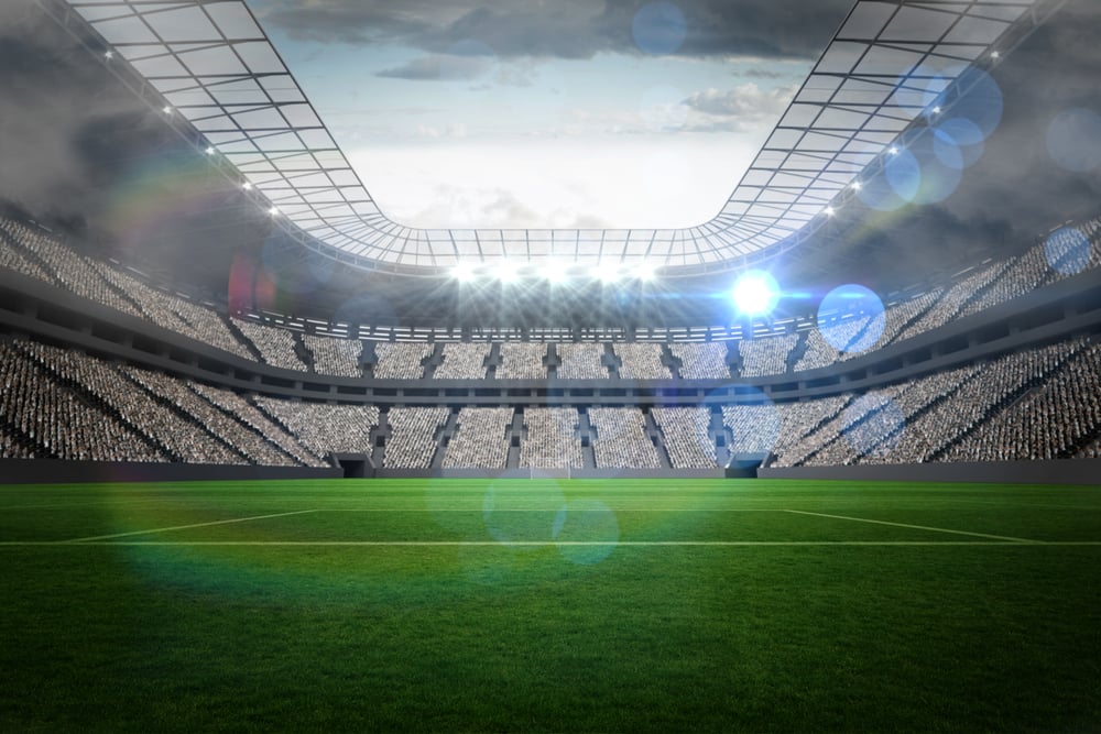 Large football stadium with lights under cloudy sky-1