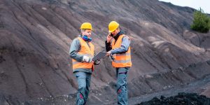 Workers standing in open-cast mining operation pit